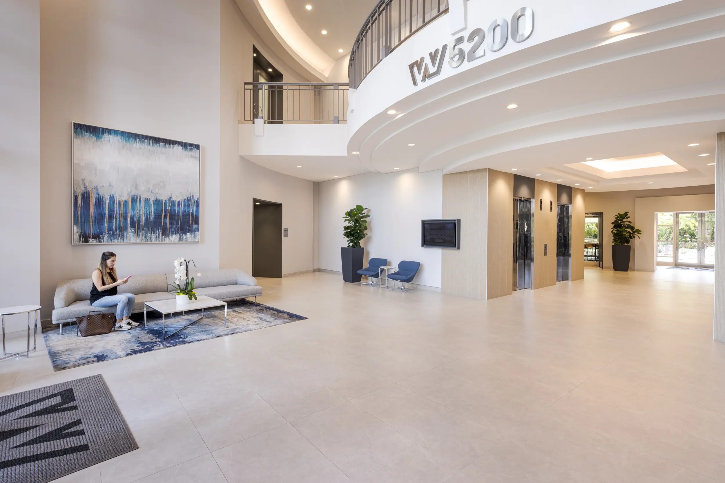 Contemporary lobby at Waterford 5200 featuring integrated digital display walls and refined beige flooring.webp